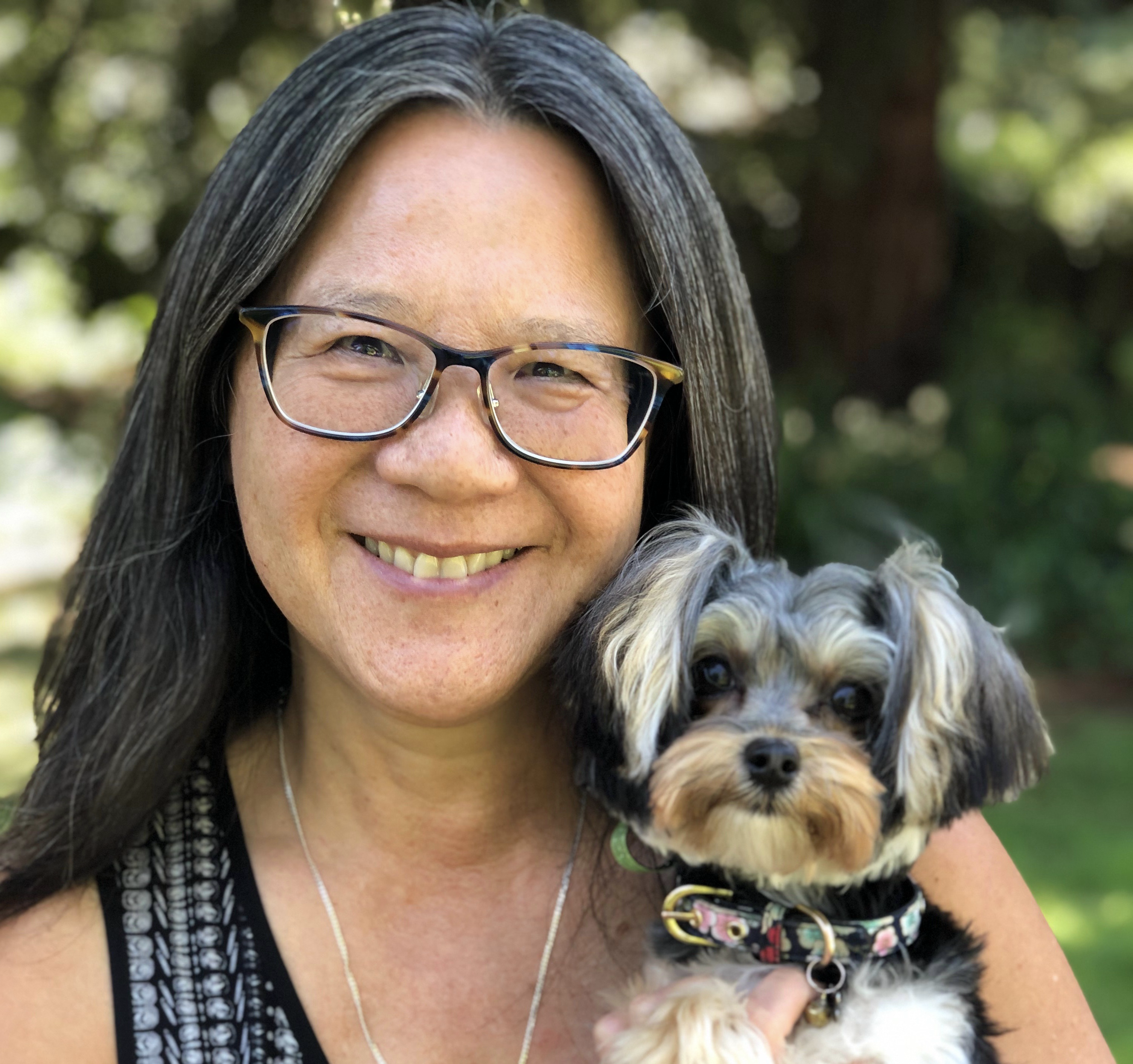 Picture of Dr. Ku holding a small dog (Wanda).
